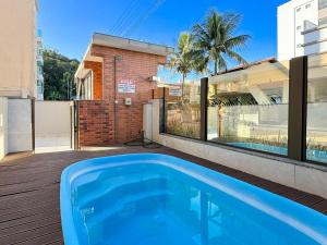 a swimming pool on a deck next to a house at Brisa de Palmas - Res. Maria Eduarda - GCR003 in Governador Celso Ramos