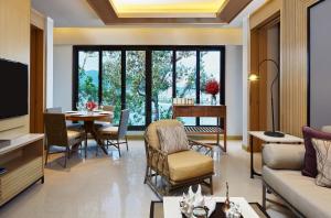 a living room with a couch and a table and chairs at Amari Phuket in Patong Beach