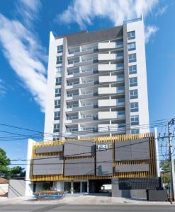a tall white building with a blue sky at Cityscape Views - New 2BR Retreat in Asuncion