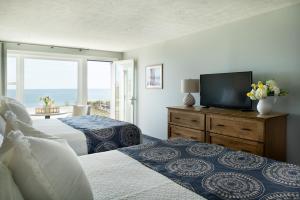 a bedroom with two beds and a flat screen tv at Cutty Sark Motel in York Beach