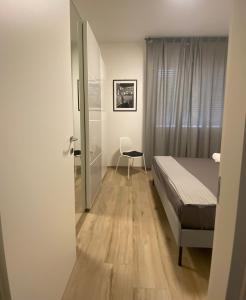 a bedroom with a bed and a chair in it at Casettadellafotografia in Senigallia