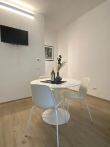 a white dining room with a white table and chairs at Casettadellafotografia in Senigallia