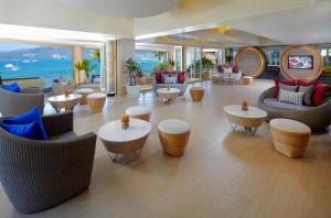 a lobby with couches and tables and a view of the ocean at Amari Phuket in Patong Beach