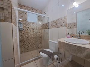 um banheiro com vaso sanitário, pia e chuveiro em Casa 2qts Vaga centro Arraial do cabo 5 min Praia em Arraial do Cabo mais 19 fotografias