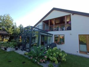 a white house with a balcony and some plants at Barytowy apartament in Tarnowskie Góry