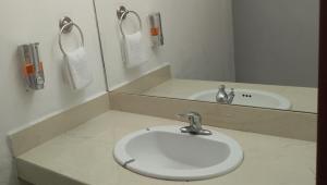 a bathroom with a white sink and a mirror at Hotel Estrella in Matamoros