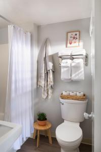 a bathroom with a toilet and a shower and towels at Cutty Sark Motel in York Beach
