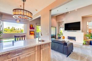 a kitchen and living room with a couch and a tv at Community Pool Access Chic Palm Springs Condo in Palm Springs