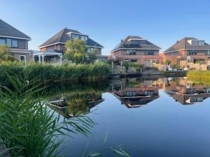 a group of houses next to a river at Hart van Petten in Petten
