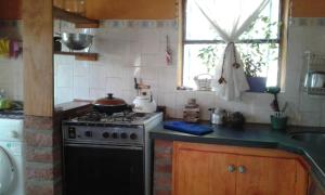 a kitchen with a stove and a sink at Habitacion serrana Stella Maris in Río Ceballos +5 photos