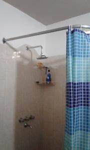 a bathroom with a shower with a blue shower curtain at Habitacion serrana Stella Maris in Río Ceballos