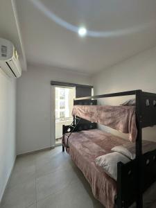 ein Schlafzimmer mit einem Bett in einem Zimmer mit einem Fenster in der Unterkunft Bluu Habitat Lagoon Condos in Mazatlán