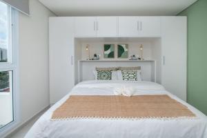 una camera da letto con un grande letto bianco e armadi bianchi di Stylish 2BR Apt in Top Location ad Asunción