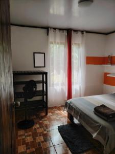 a bedroom with a bed and a red curtain at Casa Cristy in Puerto Viejo