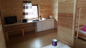 Una habitación con un escritorio y un televisor en una cabaña. en Lilmil, en Wiele