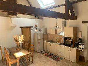 a kitchen with a table and a refrigerator at La p'tite maison in Mandres