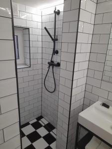 a shower in a white tiled bathroom with a sink at Hory Opawskie in Głuchołazy +27 photos