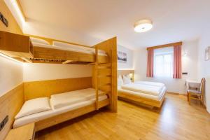 a room with two bunk beds and a table at Appartement Anger in Lutago