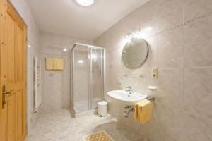 a bathroom with a shower and a sink and a mirror at Appartement Anger in Lutago +2 photos