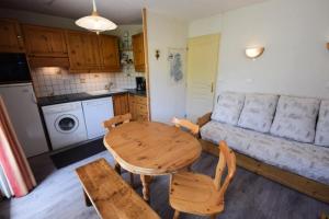 a living room with a table and a couch at Résidence Les Hameaux I - 2 Pièces 4 Pers - LES HAMEAUX 1 - 348H1 - PLAGNE VILLAGES MAE-9074 in La Plagne Tarentaise