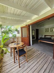 a wooden deck with a table and a bed at Casa Shambala B&B in Las Terrenas