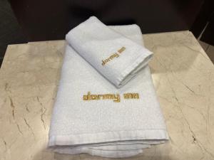 a white towel with the words dennyimimum on it at Dormy Inn Express Koriyama in Koriyama