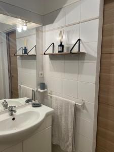 a white bathroom with a sink and a mirror at Appartement 2 pièces bord de mer in Linguizzetta