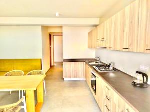 a kitchen with wooden cabinets and a counter top at Stylish Lagoon Paradise Apartment Boa Vista in Sal Rei