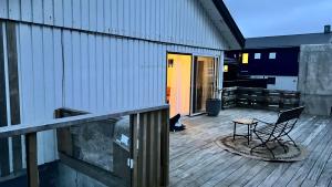 a chair sitting on the deck of a house at Lyst & Moderne Hus in Tórshavn +14 photos