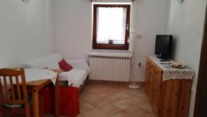 a living room with a couch and a television at Apartmani Ana Schon in Cres