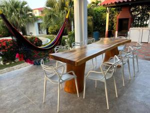 a wooden table and some chairs and a hammock at Villa Las Marias in Santa Verónica
