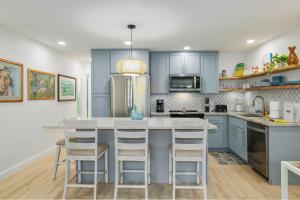 a kitchen with blue cabinets and a kitchen island with stools at Kihei Kai Oceanfront Condos in Kihei