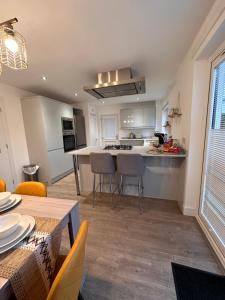 a kitchen and living room with a table and chairs at Elite 3 bedroom family house with free parking in Newton Mearns