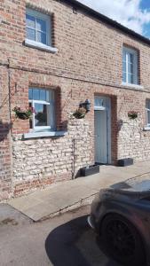 a brick building with a door and a car parked outside at White Swan Cottage in Hunmanby