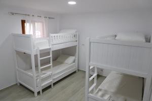 two white bunk beds in a white room at Aral Hostel in Berat