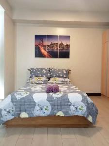 a bedroom with a bed with a bedspread on it at Mactan Newtown 2 Bedrooms Suite in Lapu Lapu City