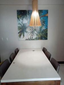 a white table with chairs and a light above it at Mactan Newtown 2 Bedrooms Suite in Lapu Lapu City