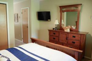 ein Schlafzimmer mit einem Bett und einer Kommode mit Spiegel in der Unterkunft Siggi's Longhorn Lodge in Eden