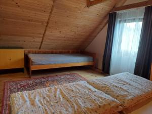 a attic bedroom with two beds and a window at Domek nad jeziorem, łódka, kajak in Zalewo