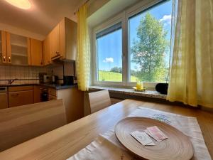 a kitchen with a table and a large window at Haus Steinfeld in Kirchberg an der Raab