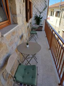 a table and chairs sitting on a balcony at Os 3 RRR in Vilela do Tâmega