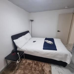 Entire-2 Bedroom Apartment with Driveway,1Free Parking في نوتينغهام: غرفة نوم عليها سرير وفوط زرقاء