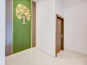 a hallway with a painting of a tree on the wall at The Nines Hotel & Restro in Kālādhūngi
