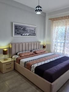 a bedroom with a large bed in a room at Gjiri I Lalzit apartament in Draç