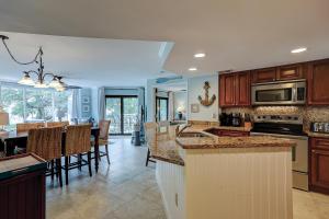 a kitchen with wooden cabinets and a dining room at Wonderful Luxury Updated Villamare with Pool Bikes & Beach Gear included in Hilton Head Island