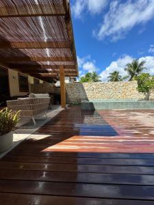 a deck with a bench and a stone wall at Apartamento Barra VIP in Marau