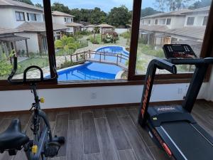a gym with a treadmill and a view of a pool at Apartamento Barra VIP in Marau