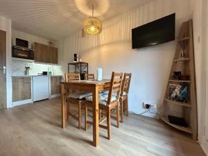 a dining room with a table and a kitchen at Chalets du Village - Tily Home - Studio centre village in Villard-de-Lans +12 photos