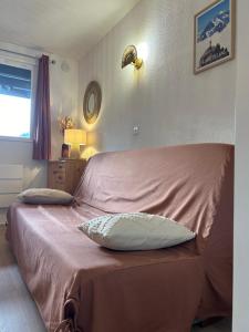 a bed with two pillows on it in a bedroom at Chalets du Village - Tily Home - Studio centre village in Villard-de-Lans