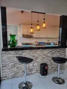 una cocina con 2 taburetes frente a un mostrador en Apartamento Melgar, Villa Flórez, en Melgar